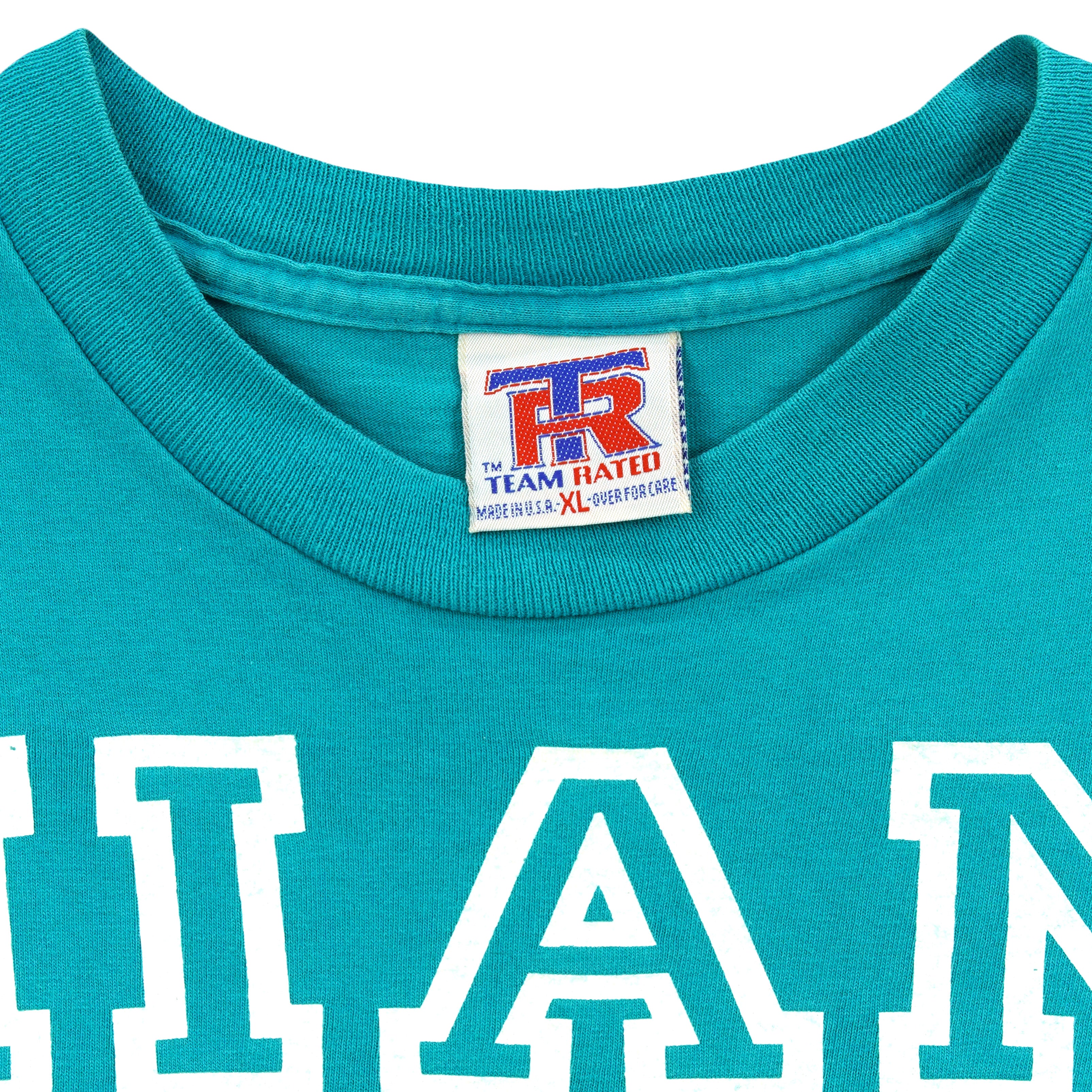 Close-up of the Team Rated XL label inside the teal Dolphins T-shirt