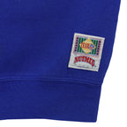 Nutmeg hem patch and minor sleeve marks on the blue sweatshirt