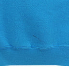Close view of a small dark mark near the blue back hem