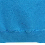 Close view of a small dark mark near the blue back hem